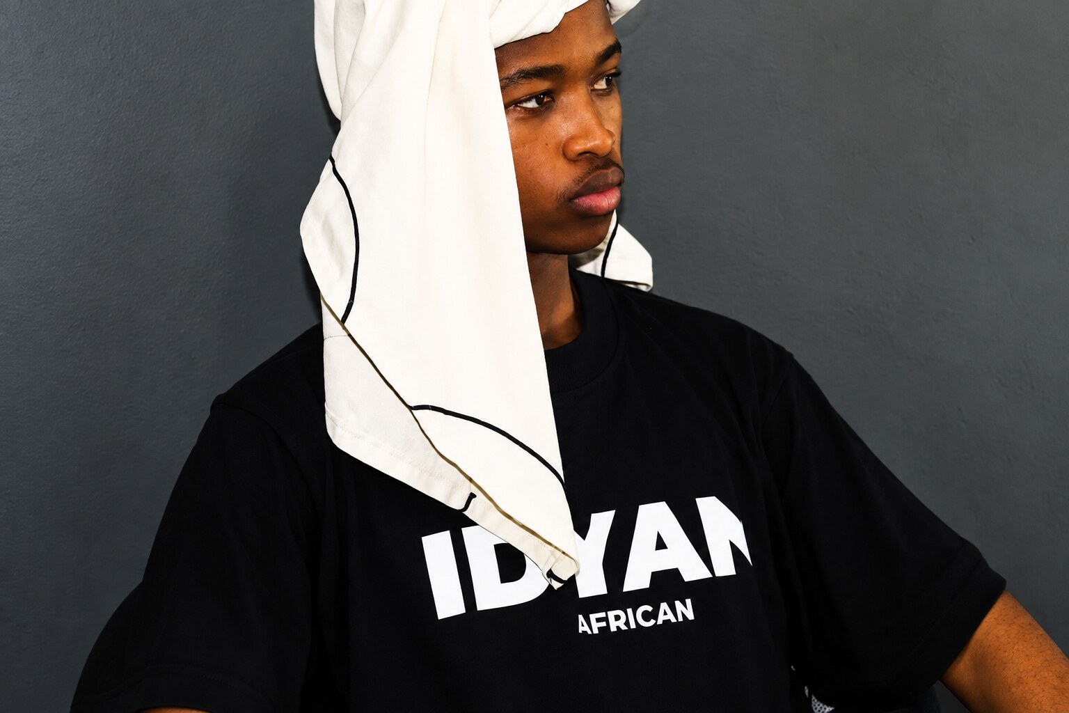 Young man in an IDYAN. tee and white headwrap